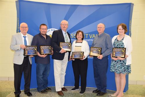 Hall of Achievement winners pose in a group with their plaques